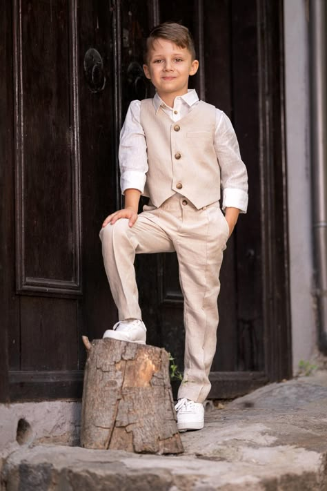 Cute beige linen 3 piece set for boys. Formal boys linen summer set is perfect for creating a stunning, completed look that is suitable for communion, birthdays and formal family get together. Soft long sleeves white linen polo shirt with chest pocket, tapered pants with elastic on the waist and side italian pockets. Closure with zipper and button, 2 fake flap pockets on the rare. Stylish classic single breasted vest with jetted chest pocket, fully lined. Made from high quality fabric with lots Ring Boy Outfits, Rustic Wedding Outfit, Dress Shirt Outfit, Kids Wedding Outfits, Boys Formal Wear, Wedding Outfit For Boys, Boy Baptism Outfit, Cream Suit, Bearer Outfit