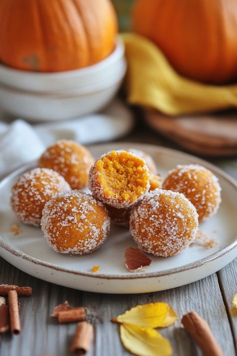 Pumpkin spice truffles coated in sugar, with a bite taken out of one, on a rustic wooden table. Pumpkin Pie Energy Bites, Pumpkin Spice Energy Balls, Pumpkin Spice Balls, Pumpkin Pie Balls, Pumpkin Energy Bites, Pumpkin Energy Balls, Healthy Pumpkin Cheesecake, Pumpkin Balls, Energy Balls Healthy