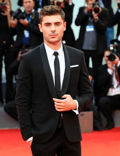 Zac Efron knows how to rock the classic tux with a skinny tie. Let your date switch it up a bit. Maybe a colored tie and vest to match your dress or switch it up even more by letting him get a colored shirt! Black Prom Suits For Guys, Zac Efron Suit, Black Prom Suits, Black Tie Wedding Attire, Suits For Guys, Black Tuxedo Wedding, Mens Tux, Wedding Suits Men Black, Groom Suit Black