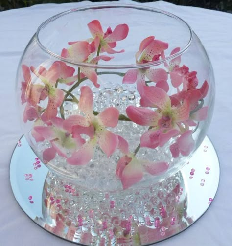 artificial orchids in a simple glass fish bowl but add a candle Fish Bowl Vase Ideas, Orbeez Centerpieces Flowers, Fishbowl Decoration Ideas, Fish Bowl Ideas Diy, Fish Bowl Decor Ideas, Glass Bowl Decor Ideas, Flower Bowl Centerpiece, Fish Bowl Centerpiece, Fish Bowl Centerpiece Wedding