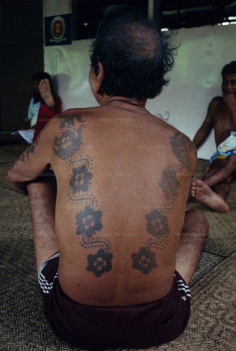 DAYAK TATTOOS, MALAYSIA. Sarawak, Borneo, South East Asia.  Dayak, 'Iban', man with tattoos, longhouse verandah. Tropical rainforest and one of the world's richest, oldest eco-systems, flora and fauna, under threat from development, logging and deforestation. Home to indigenous Dayak native tribal peoples, farming by slash and burn cultivation, fishing and hunting wild boar. Home to the Penan, traditional nomadic hunter-gatherers, of whom only one thousand survive, eating roots, and hunting wild Malaysian Tattoo Traditional, Malaysia Tattoo, Malaysian Tattoo, Iban Tattoo, East Kalimantan, Borneo Tattoo, Literary Tattoos, Cross Tattoo For Men, Marquesan Tattoos