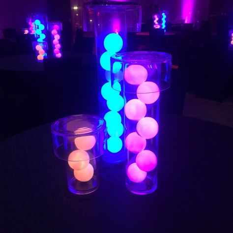 Neon lights - transform the space into a true Vegas night club.  Centerpieces created with different sized glass cylinders and glow balls Glow In The Dark Centerpieces, Neon Centerpieces, Neon Club, Neon Karaoke Party, Glow Backdrop Neon Party, Neon Party Stage Design, Neon Sweet 16 Ideas Blacklight Party, Futuristic Party, Glow Theme Party