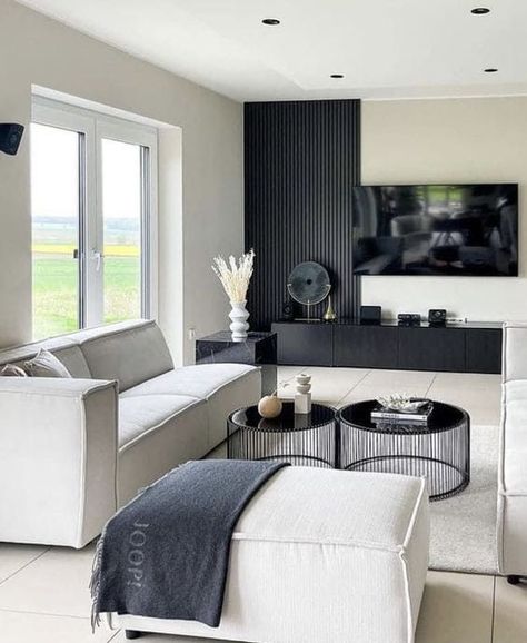 Are you a newbie in designing a dark accent wall but intrigued by its beauty? Check out this design! Instead of painting the entire wall in black, you can choose wall panels and install them halfway up the wall. #BlackWallDecor #DarkFeatureWall #BlackWallIdeas #MinimalistBlackWall #DarkWallPaint #BlackLivingRoomWall #BedroomFeatureWall #BlackWallTrends #LuxuriousBlackWalls Bloxburg Basement, Black Living Room Decor, Modern Apartment Living Room, Black And White Living Room, تصميم داخلي فاخر, Bar Basement, Decor Fireplace, Apartment Living Room Design, Black Living Room