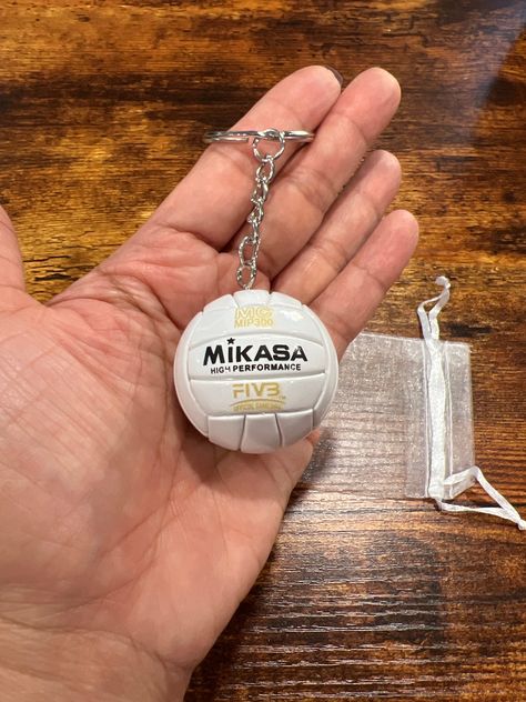 Introducing a miniature  Mikasa volleyball with ridges, designed to be a charming accessory for your backpack, keys, or as a rear view ornament. Crafted from sturdy hard leather like material, it features a durable silver keychain attachment. Additionally, it comes with an adorable white "net" pouch for safekeeping. This miniature volleyball is a must-have for volleyball players and enthusiasts alike. Volleyball Keychain Acrylic, Athletic Keychain, Volleyball Wishlist, Mikasa Volleyball, Volleyball Keychain, Volleyball Accessories, Volleyball Skills, Volleyball Practice, Volleyball Humor