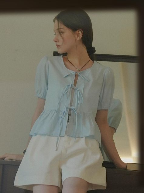 Blouse in an airy woven cotton fabric. Round neckline, an open front with ribbon ties, and short puff sleeves. Gently flared peplum.  - Regular length- Short sleeves- Peplum- Round neck Ribbon Top Outfit, Korean Blouse Outfit, Soft Blue Outfit, Puff Sleeves Outfit, Tie Front Top Outfit, Peplum Top Outfits, Vietnam Clothes, French Trip, Ribbon Blouse