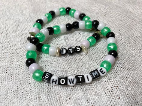 "This cute beaded bracelet sets is calling all Beetlejuice fans!  From the infamous cult classic, the double set features one of his famous lines:  \"It's showtime!\"  The simple set is made with signature movie color pony beads and is accented with small pearl bead slices as well as metallic silver stars.   Enjoy a multitude of beads on this stretchy double set and make a statement. The cording is reinforced with E6000 glue at the knot." Pony Bead Bracelets Ideas, Halloween Kandi, E6000 Glue, Star Pearl, Diy Kandi Bracelets, Pony Bead Bracelets, Diy Kandi, Double Bracelet, Kandi Ideas