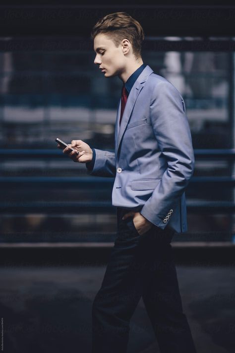 A Young Businessman Walking And Looking At His Cell Phone | Stocksy United Checking Phone Pose, Guy Leaning Against Wall, Looking At Phone Reference, Hand In Pocket Reference, Hands In Pockets Pose, Man Holding Phone, Phone Reference, Hand In Pocket, Walking Poses