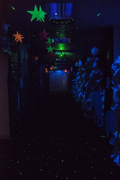 Black light hallway featuring the "northern lights"! Suspend a star projector laser light from the ceiling along with neon colored large stars for a fun effect at #OperationArctic Arctic Vbs Decorations, Homecoming Decorations Hallway, Black Light Dance, Arctic Decorations, Operation Arctic Vbs, Homecoming Hallways, Diy Black Light, Arctic Vbs, Space Vbs