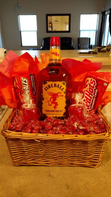 Fireball with edible cinnamon jolly rancher shot glasses, red hots, hot tamales, atomic fireballs Moonshine Basket Gift Ideas, Fireball Christmas Gift, Fireball Basket Gift Ideas, Fireball Gift Basket, Drink Basket, Liquor Gift Baskets, Alcohol Gift Baskets, Fundraiser Baskets, Liquor Gifts