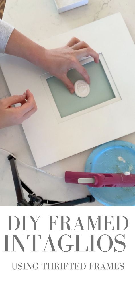 A photo of a hand holding an intaglio in the center of a photo mat with a hot glue gun next to it. How To Gild A Frame, How To Frame Intaglios, Coin Frame Display Ideas, Diy Painting Frames Ideas, Diy Framed Intaglios, How To Sign Artwork, How To Make Intaglios, Intaglio Printmaking Ideas, Intaligo Print