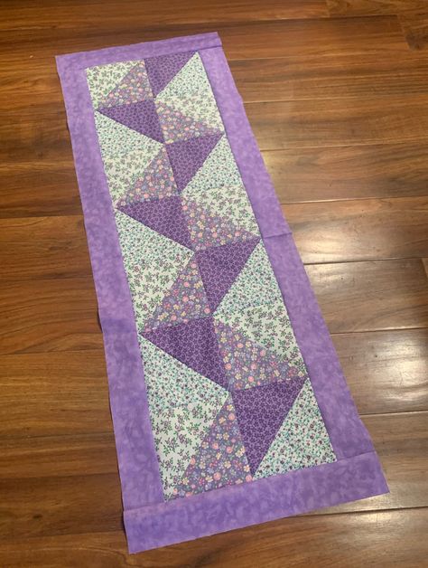 "Floral Pathway Table Runner Pattern by Simpson Designs Studio, Physical Pattern This is the physical version, not digital Finished size - 14\" x 39\"  Skill level - beginner Materials Dark Purple - 1/4 yd Medium Purple - 1/4 yd Solid Purple - 1/4 yd White Floral # 1 - 1/4 yd White Floral #2 - 1/4 yd Binding - 1/4 yd Backing - 1 1/3 yds Batting - 22\" x 47\"   SDSQD046 Check us out on Instagram at @simpsondesignsstudio" Quilted Table Runners Patterns Free, Free Table Runner Quilt Patterns, Quilted Table Runner Patterns, Floral Pathway, Purple Table Runner, Quilt Runners, Quilted Table Runners Christmas, Table Runner Diy, Runner Pattern