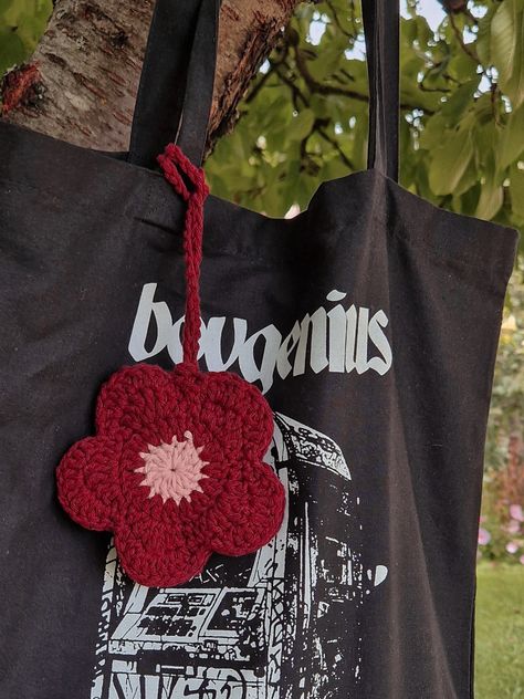 boygenius tote bag with a handmade crochet bag charm in the shape of a flower Knitted Things To Sell, Crochet Bag Decoration, Bag Charm Crochet Pattern, Crochet Bag Charm Pattern, Crochet Mini Gifts, Crochet Flower Bag Charm, Crochet Bag Charm Pouch, Crochet Charm Bag, Bag Charms Crochet