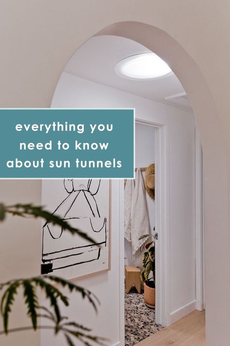 All white hallway with abstract artwork and archway Solar Tunnel Natural Light, Solar Tubes Before And After, Sun Tubes Natural Light, Skylight Before And After, Velux Sun Tunnel, Solar Tubes Skylight, Sun Tunnel Skylight Bathroom, Light Tubes Skylight, Adding Skylights Before And After