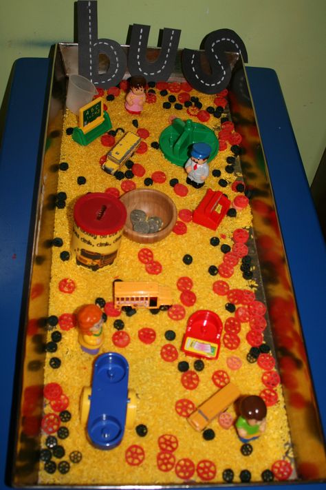 Wheels on the Bus Sensory Bin- yellow rice, red & black wagon wheel pasta, buses, coins and coin can, school toys Wheels On The Bus Sensory Bin, Wheels On The Bus Activities For Preschool, School Bus Sensory Bin, Bus Sensory Bin, The Wheels On The Bus Activities, Bus Activities For Preschool, Wheels On The Bus Activities, Wagon Wheel Pasta, Sensory Tables