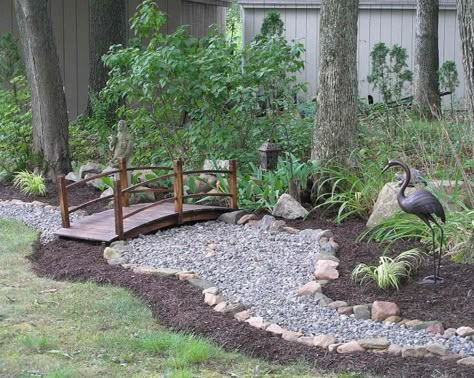 I love the idea of a rock creek bed winding along the back edge of the garden. The footbridge lends a Zen element to the design. Dry Retention Pond Landscaping, Lodge Style Landscaping, Small Backyard Bridge Ideas, Backyard Bridges Dry Creek, Bridge Over Dry Creek Bed, Drycreek Landscaping, Dry Pond, Dry River Bed, Arched Bridge