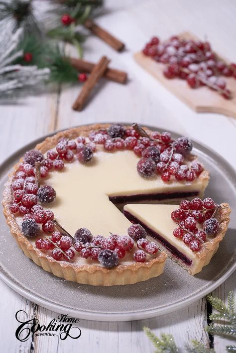 This Cranberry White Chocolate Tart is a delicate and elegant dessert you can prepare for Christmas. It is one of the most beautiful, colorful and flavorful tarts I have ever prepared. The tart consists of a pâte sablée crust made with almonds,  a white chocolate almond crunch, a cranberry orange layer and white chocolate ganache. The tart is beautifully decorated with red currants, sugar-coated cranberries, and cinnamon sticks, all dusted with powdered sugar. Tart Christmas, Cranberry Pistachio Fudge, White Chocolate Tart, Cranberry Orange Cookies, Cranberry Tart, Christmas Cranberry, Cranberry White Chocolate, Sponge Cake Filling, Cranberry Dessert