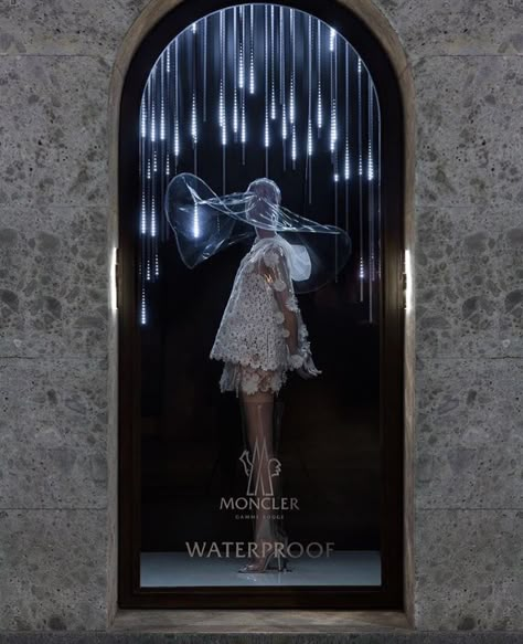 Type of display: Semi- Realistic. This visual display is promoting the waterproof outfit. The attention is drawn from the posture of the model and the neon lights hanging down around it, also the one-window display helps people focus just on the item Fashion Window Display, Window Display Retail, Fashion Displays, Store Window Displays, Visual Merchandising Displays, Window Display Design, 23 March, Retail Inspiration, Design Logos