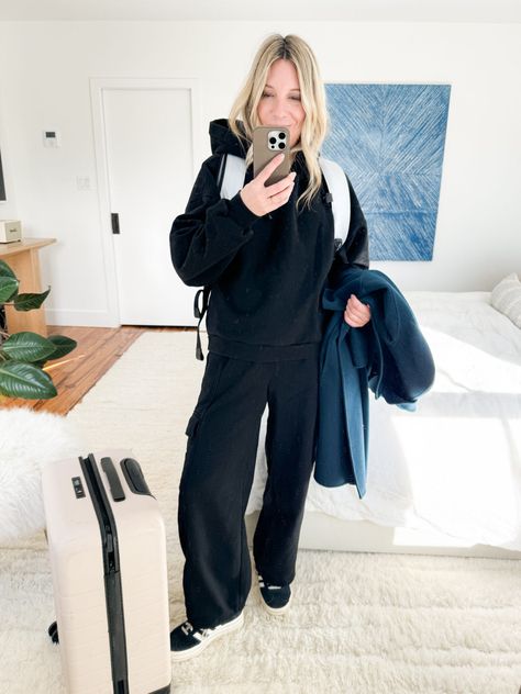 When pulling together a cool, cohesive airport outfits with sweatpants, start with a matching set in black or navy. They often look more expensive than they are, and black sweatpants can also – at a distance – vibe as real pants. I've been living in this set from Gap. Just add a wool wrap coat & some platform Adidas Gazelles and the whole look reads chic (but still comfy!) #AirportOutfit #AirportOutfitWinter #WinterAirportOutfit #SweatSet #WhatToWearOnThePlane #WinterTravelOutfit Sweats Airport Outfit, Cropped Sweatpants Outfit, Winter Sweatpants Outfit, Black Sweats Outfit, Airport Style Winter, Outfit Ideas Sweatpants, Wide Leg Sweatpants Outfit, Outfits With Sweatpants, Platform Adidas