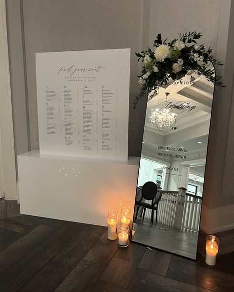 The Most Romantic Trio! We’re in love with how the bride paired a mirror welcome sign with a beautifully designed seating chart and a sleek acrylic base! The reflection of the mirror adds a touch of elegance, while the seating chart guides guests with a sophisticated flair. Just breathtaking… this combo is as sweet as a kiss! 💋👌🖤 #monthillgolfandcountryclub #hamontweddings #weddinginspiration #weddingsignage #weddingsigns #weddingseatingchart #seatingchart #seatingchartideas #seatingplanide... Large Mirror Seating Chart Wedding, Big Mirror Seating Chart, Wedding Welcome Sign And Seating Chart, Floor Length Mirror Seating Chart, Full Length Mirror Wedding, Mirror Table Seating Chart Alphabetical, Mirror Seating Chart Long Tables, Seating Chart Mirros, Mirror Welcome Sign