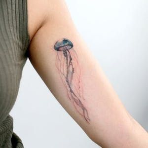 15 Beautiful and Vibrant Jellyfish Tattoos | Tattoodo Small Wave Tattoo, 16 Tattoo, Tattoos Black Women, Jellyfish Tattoo, Wave Tattoo, Omerta Tattoo, Hawaiian Tattoo, Geniale Tattoos, Medusa Tattoo