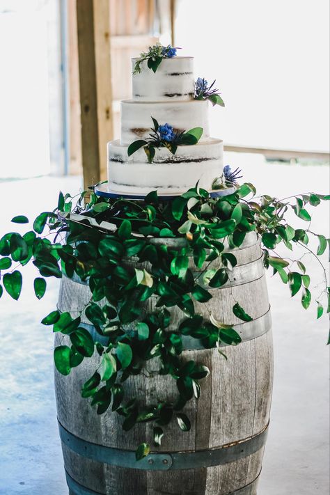 Set your wedding cake up on a barrel and wrap with greenery. Made by Teresa Lynn Cakes LLC Barrel Wedding Cake Table, Barrel Wedding Cake, Semi Naked Wedding Cake, Wine Barrel Wedding, Barrel Cake, Barrel Wedding, Large Floral Arrangements, Barrel Table, Wedding Cake Table