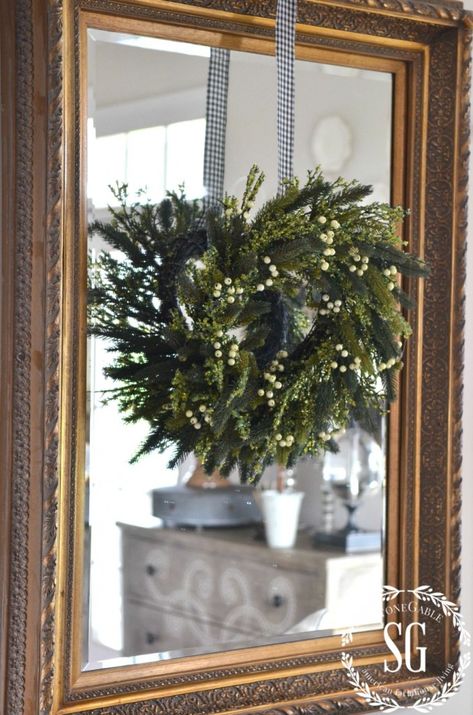 CREATIVE WAYS TO USE CHRISTMAS WREATHS-wreath hanging on mirror-stonegableblog.com Wreath Hanging From Ribbon On Mirror, Christmas Wreath On Mirror, Wreath Hanging Ideas, Wreath Over Mirror, Oval Mirror Decor, Ribbon Mirror, Wreath On Mirror, Wreath Mirror, Christmas Mirror