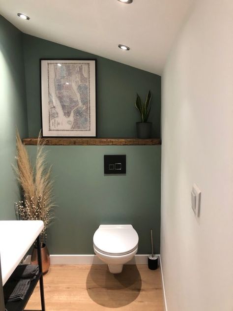 a small boho powder room under the stairs with green walls, a shelf with decor, a toilet, a vanity and some pampas grass Boho Powder Room, Room Under The Stairs, Minimalist Powder Room, Klein Toilet, Contemporary Powder Room, Small Downstairs Toilet, Bathroom Under Stairs, Toilet Room Decor, Wc Design