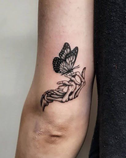 Woman In Flowers Tattoo, 2x2 Tattoo Size, Skeleton Hand Holding Butterfly Tattoo, Landed Butterfly Tattoo, Flip Off Tattoo, Skull Hand With Butterfly Tattoo, Women Gothic Tattoo, Skeleton Hand With Butterfly Tattoo, Paperclip Tattoo Meaning