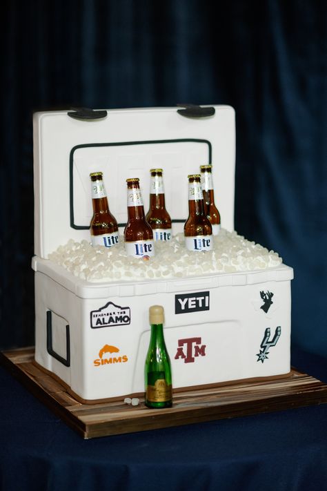 A groom's cake in the shape of a Yeti cooler with pretend ice and Miller Lites. The cooler is decorated with various stickers like the Spurs logo, "Remember the Alamo" and the Texas A&M logo. Yeti Grooms Cake, Yeti Cake, Grooms Cake Ideas Unique, Miller Lite Cake, Cake Stock, Greek Pastries, Yeti Cooler, Miller Lite, Tea Bar