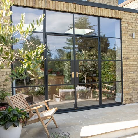 Crittall-style glazing extends from floor to ceiling, adding to the feeling of height and opening up the views of the garden at one of our South Woodford projects. #crittallstyle #oversizedglass #londonarchitects Rear Extension Crittal Doors, Garage Door Conversion, Crittall Windows, Crittall Doors, Crittal Doors, Aluminium French Doors, Kitchen Extension Ideas, Crittal Windows, Aluminum Windows