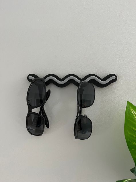 Keep your sunglasses organized and within reach with our stylish 3D Printed Wall Mount Sunglasses Holder! This sleek and modern design is perfect for displaying your favorite pairs while saving space. Available in a variety of vibrant colors, you can choose the perfect match for your décor. Made from durable, high-quality materials, this holder is easy to install and adds a touch of convenience to any room. Elevate your accessory game with this must-have organizer! Choose from many colors to cus Ceramic Sunglasses Holder, Hat And Sunglasses Rack, Sunglasses Holder Aesthetic, Aesthetic Room Organization Ideas, Sunglasses Holder Wall, Sunglass Holder Diy, Diy Sunglasses Organizer, Sunglasses Display Diy, Office Cubical Decor