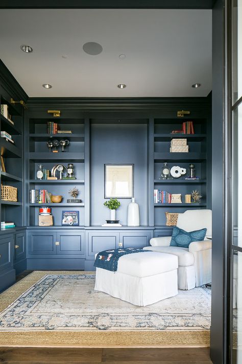 Navy Blue Den with Built-in Shelves and Cozy Chair and Ottoman Navy Blue Reading Nook, Blue Shelves Bookshelves, Navy Blue Shelves, Navy Blue Library Room, Blue Bookshelves Living Room, Navy Blue Den, Navy Blue Bookshelves, Navy Blue Built Ins, Navy Bookshelves