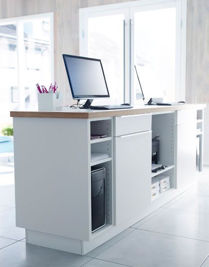 White kitchen cabinets with doors, drawers and worktop used as a front desk.  Definitely doing this. Ikea Reception Desk, Front Desk Design, Ikea Office, Retail Counter, System Furniture, Store Design Boutique, Pinterest Design, Pharmacy Design, Ikea Desk