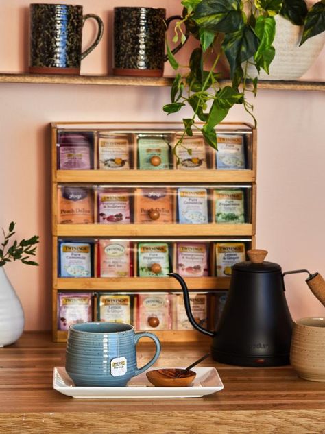 A wooden tea box with a selection of fine teas and a gooseneck water kettle reminds you to set aside time for tea. Grab a terracotta mug and enjoy a steaming cup of your favorite tea as stress melts away. Tea Coffee Organization, Tea Nook In Kitchen, Tea Bar At Home, Tea And Coffee Organization, Bedroom Tea Station, Tea Station Ideas Small Spaces, Coffee Tea Corner, Bedroom Coffee Station, Tea Bar Ideas