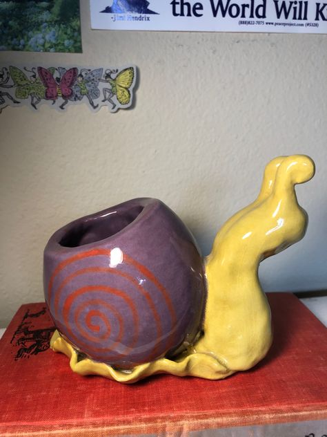 a ceramic snail with a pot made out of its shell. it is purple and yellow. Ceramic Room Ideas, Pitch Pots Ideas Clay, Unique Pinch Pot Ideas, Pinch Pots Aesthetic, Ceramic Pieces Ideas, Funky Ceramics Ideas, Craft Clay Ideas, Clay Ideas Sculpture, Ceramic Projects High School