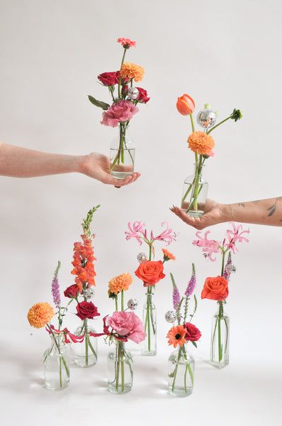 These 10 little bud vases are a fun way to sprinkle happy party vibes throughout your home. And once the flowers have passed, these vases are a great excuse to order our Bundle of Blooms, so you can experiment on your own! Curbside Pickup: FreeShipping: Not Available for this itemDelivery: Rates are based on distance from Studio City Shop (calculated at checkout). Order min. starts at $75 and increases with distance. Please place same-day delivery orders before 2 pm. Deliveries arrive Mo Wildflower Small Centerpiece, Simple Colorful Centerpieces, Flowers In Cans, Bud Vases Bright Flowers, Bud Vases With Wildflowers, Bright Bud Vases Wedding, Bridal Shower Bud Vases, Pink And Orange Bud Vases, Whimsical Bud Vases