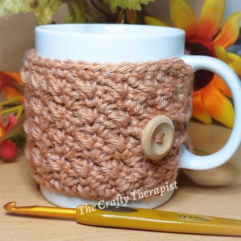 A free mug cozy crochet pattern to keep your coffee or tea warm. This easy crochet mug cosy pattern is beautifully textured with the crochet suzette stitch to look gorgeous and feel lovely. This quick crochet project makes a perfect handmade christmas gift that you can whip up fast. It's a great 1 hour crochet project that you'll easy finish in an hour or less! Crochet Suzette Stitch, Mug Cozy Crochet Pattern, Mug Cozy Crochet, Stitch Mug, Coffee Cozy Pattern, Cup Cozy Crochet Pattern, Mug Cozy Pattern, Mug Cosy, Cup Cozy Pattern