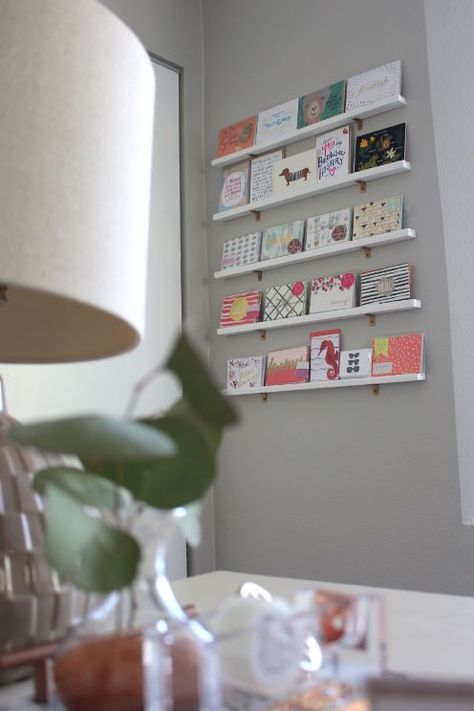 DIY Greeting Card Display Wall How To Display Greeting Cards At Home, Creative Retail Display Wall Shelves, Diy Greeting Card Display, Papercraft Storage, Card Display Ideas, Bus Boutique, Greeting Card Display Stand, Postcard Display, Office Diy