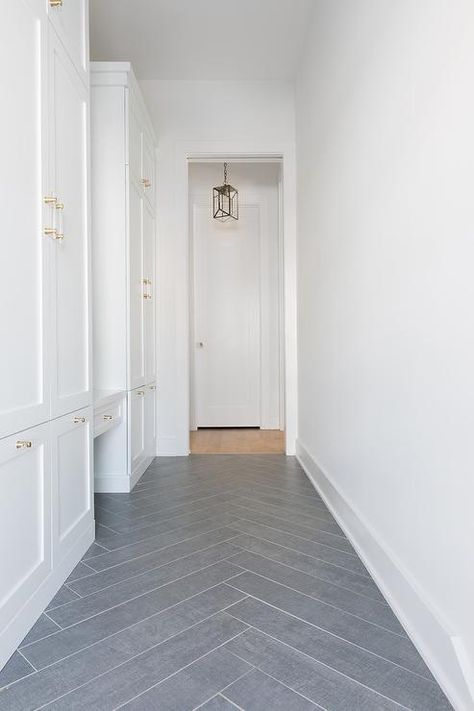 Gray slate herringbone pattern floor tiles accent white shaker mudroom cabinets stacked and fitted with brass and glass pulls. Shaker Mudroom, Herringbone Mudroom, Black Home Exterior, Kitchen Flooring Trends, Herringbone Tile Floors, Mudroom Cabinets, Mudroom Flooring, Slate Tiles, Entryway Flooring