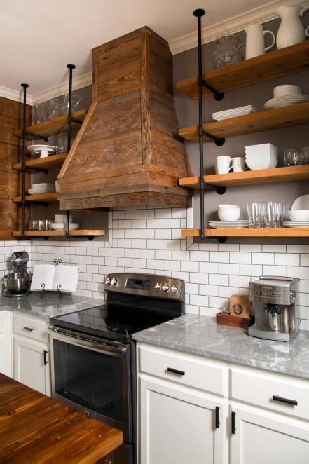 Industrial-look shelving made from plumbing pipes and reclaimed wood offers plenty of open storage above the cabinets. Industrial Farmhouse Kitchen, Dapur Rustic, Craftsman Remodel, Rustic Industrial Kitchen, Industrial Decor Kitchen, Rustic Farmhouse Kitchen Cabinets, Farmhouse Kitchen Backsplash, Fixer Upper Kitchen, Rustic Kitchen Cabinets