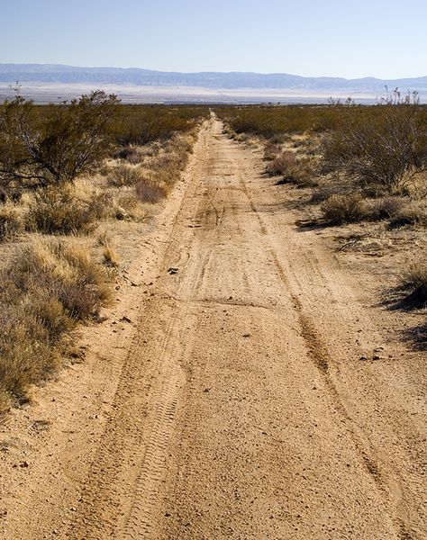 This is a desert road. Since the location of the base is in the desert, there will be areas of the ground that is worn down due to the constant movement of vehicles and humans walking, so there will be worn areas along the roads as well as the perimeter of the base from the guard patrols. Road In Desert, Pavilion Ideas, Road Photos, Logo Moodboard, Desert Background, Save The Date Video, Abandoned City, Desert Road, Desert Area