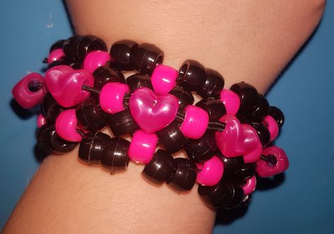 Pink and Black Kandi heart bracelet  made with pony beads and stretch cord made with the x base stitch cuff and added heart beads for decoration!  Shipping please note I am UK based - It should take 3-7 days in the UK I ship first class Royal mail For international orders it can take 7 days to 4 weeks depending on where you are located please let me know if you have a deadline date. X Base Cuff, Kandi Heart, Heart Bracelet Pattern, Bracelets Kandi, Pulseras Kandi, Kandi Cuff Patterns, Diy Kandi Bracelets, Diy Kandi, Kandi Kid