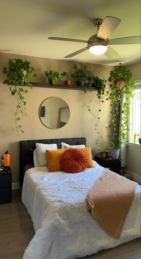 plants, orange, yellow, pillows, blanket, bedroom, bed, black bedframe, natural sunlight, gold mirror, circle mirror, pathos, plants, house plants Orange Green And White Bedroom, Orange Room Decor, Bedroom With Plants, Earth Tone Bedroom, Green And White Bedroom, Green Room Decor, Pinterest Room, Orange Rooms, Rental Kitchen