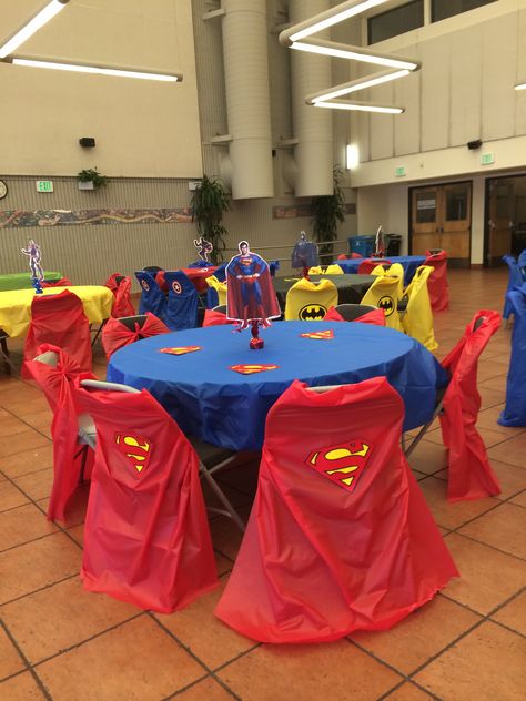 Super Man Table. I used plastic covers and made capes for the chair covers. Super Hero Table Decoration, Marvel Table Decorations, Superhero Table Decor, Super Hero Table Decor, Superman Party Decorations, Woman Superhero, Superman Birthday Party, Superman Party, Superheroes Party