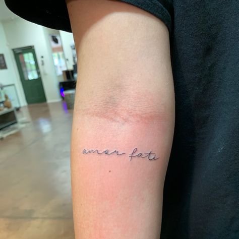 Amor fati tattoo small on inner arm Tattoo Ideas Amor, Amor Fati Meaning, Amour Fati Tattoo, Arm Tattoo Writing, Amor Fati Tattoo Fonts, Amore Tattoo Fonts, Amor Fati Tattoo Design, Fate Tattoo Ideas, Small Writing Tattoo