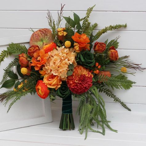 Rich tones of burnt orange, deep crimson, and golden yellow bring a burst of fall magic to your special day. This handcrafted bouquet is inspired by the warm glow of autumn, perfect for those looking to add a rustic, vibrant touch to their wedding or celebration. 🌻✨ #orangewedding #burntorangewedding #forestwedding #forestgreenwedding #fallwedding #fauxflowerarrangement #weddingflorist #weddingvendor Orange And Green Bouquet, Orange Wedding Bouquet, Forest Green Wedding, Faux Bouquet, Green Bouquet, Bridesmaid Bouquets, Faux Flower Arrangements, Parts Of A Flower, Wedding Flowers Summer