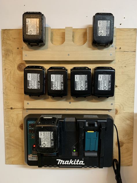 Cheap easy Makita Battery station. Used 1/4" plywood and cut out the U shapes with a band saw then mounted on 3/4" thick stock with 1/2" plywood backer. The U shape is 2 1/8" wide. For the charger I cut a piece of 1/4" plywood slightly larger than the charger and then used #6 wood screws into the rubber feet of the charger Chainsaw Organization, Makita Tool Storage, Battery Charger Station, French Cleat Storage, Workshop Cabinets, Garage Workshop Plans, Garage Organization Tips, Power Tool Storage, Workshop Layout