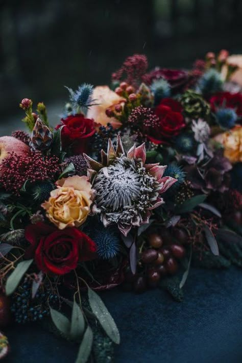 Love this time of year and all the fall color combinations. This long centerpiece is perfect for an outdoor wedding with pops of red, shades of blue, and rusty yellow. #vidachic #Destinationweddingplanner #centerpieces Halloween Wedding Centerpieces, Fall Wedding Color Schemes, Rustic Wedding Decorations, Jewel Tone Wedding, 2023 Color, Dark Wedding, Fall Wedding Decorations, Fall Wedding Colors, Burgundy Wedding