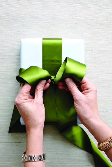 Holiday Gift Wrapping: How To Tie The Perfect Bow | Chatelaine How To Tie Gift Bow, Tying Gift Bows, How To Do A Bow With Ribbon On A Present, Tie A Bow On A Present, Easy Gift Bows With Ribbon, Tie A Gift Bow, Wrapping Bows Ribbon, Bows For Presents How To Make, Tie Ribbon On Gift