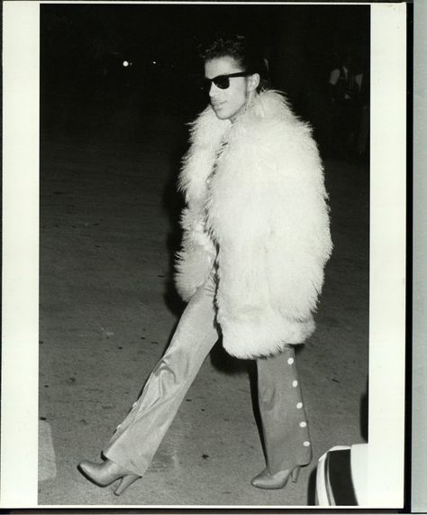 Prince, circa 1985. - The musician had an uncanny air of cool and this image of Prince, circa 1985 -- swathed in a white Mongolian fur coat, wearing Ray Ban Wayfarers, bell bottoms and his signature heeled boots -- proves it! Princes Fashion, Prince Musician, Pictures Of Prince, Photos Of Prince, Rip Prince, Prince Purple Rain, Roger Nelson, Hells Kitchen, Prince Rogers Nelson